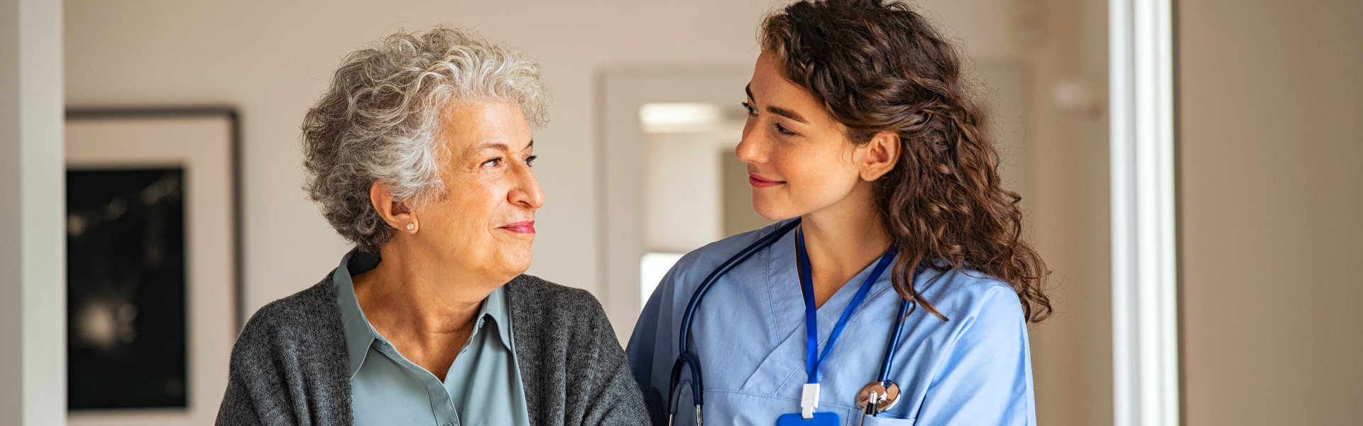 nurse and elderly woman smiling at each other